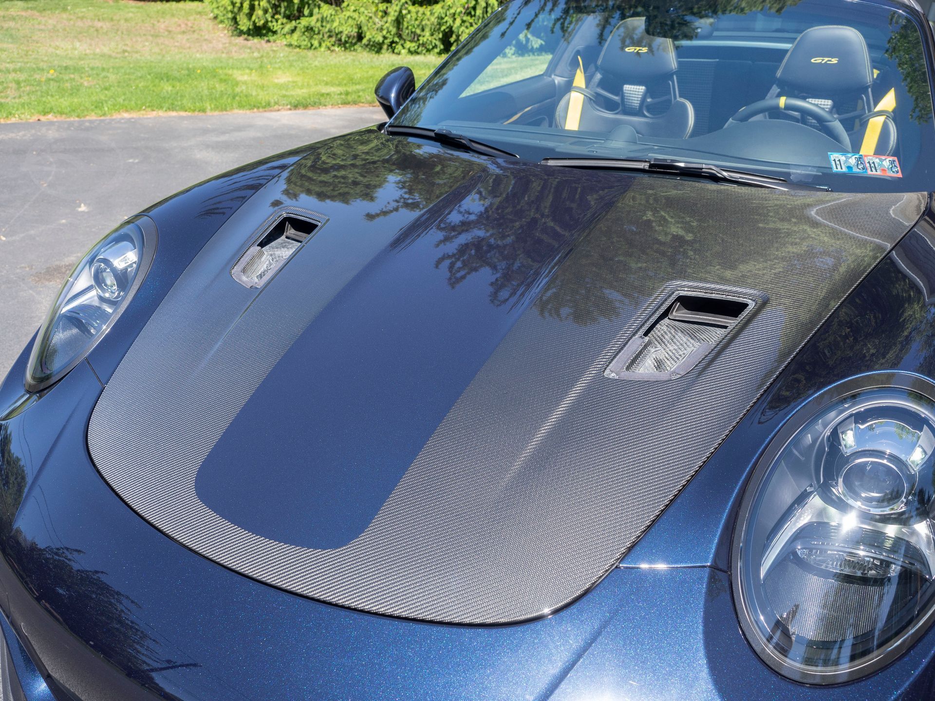 A blue sports car with a carbon fiber hood
