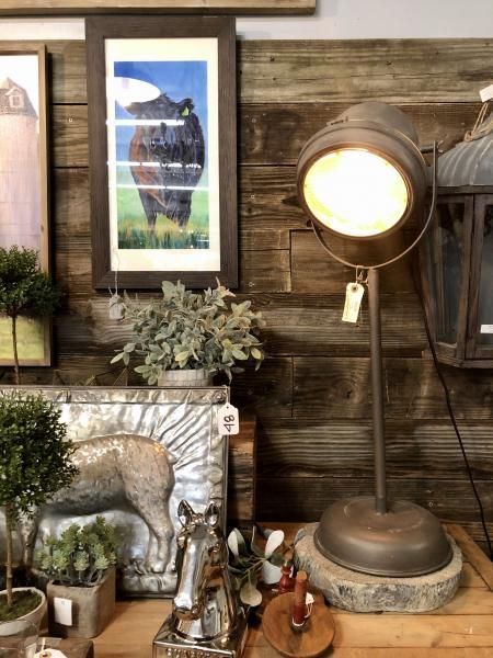 Rustic decor display with vintage lamp, framed art, and small figurines on a wooden shelf