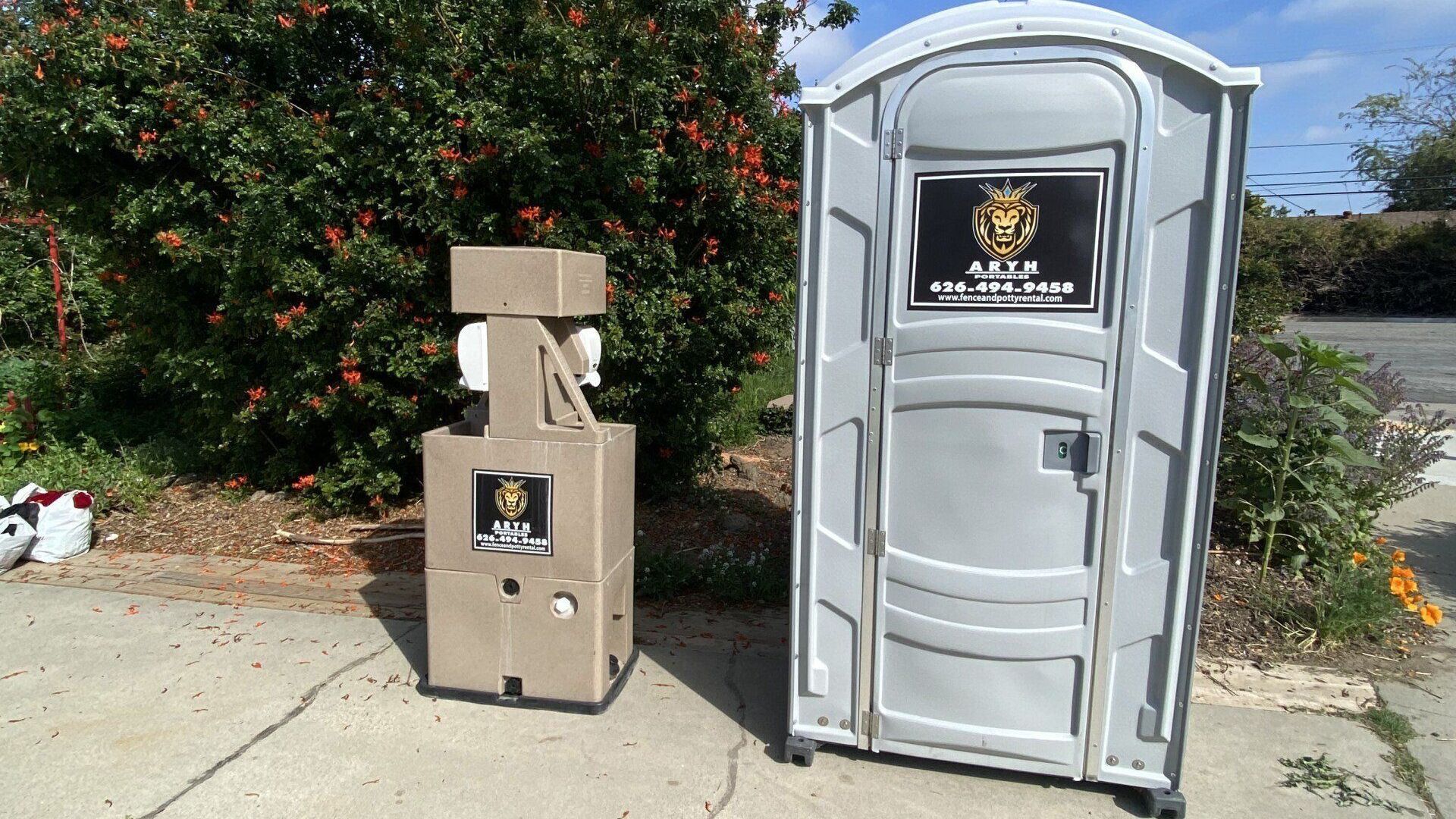 A portable toilet is next to a hand sanitizer station.