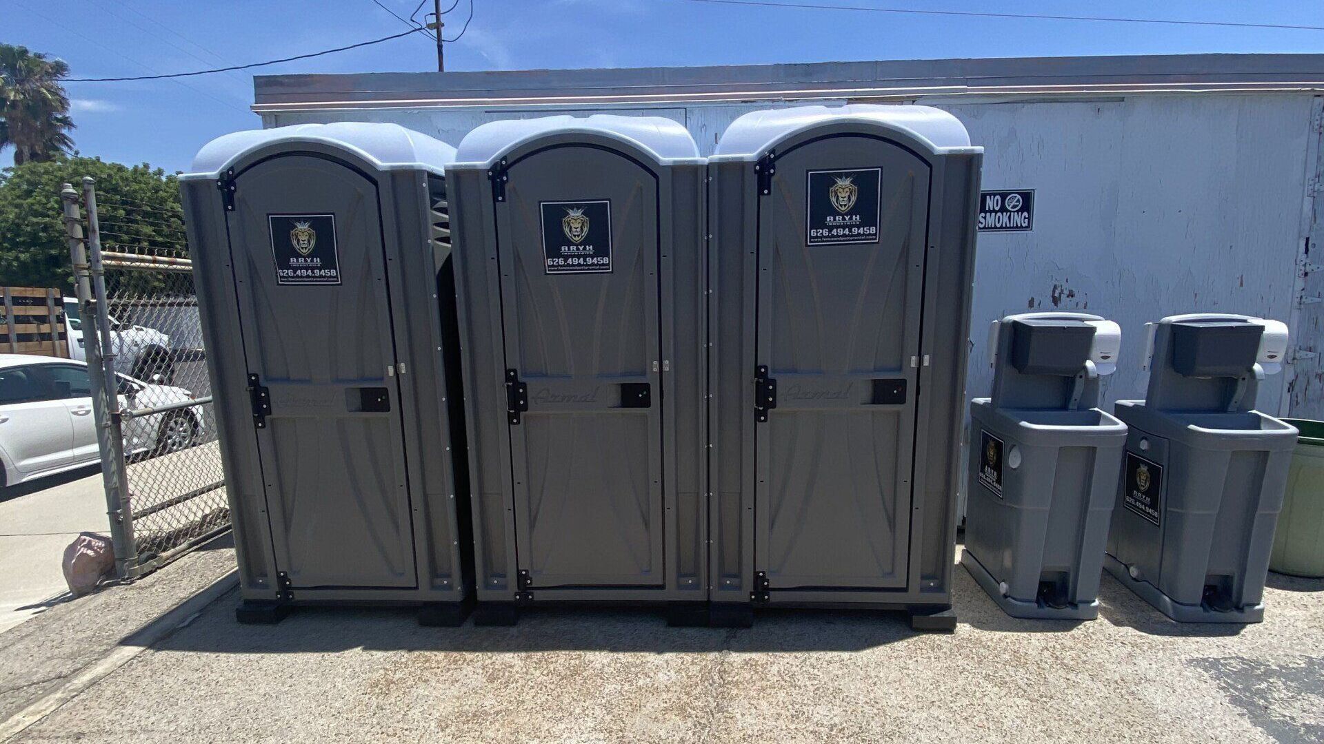 A row of portable toilets sitting next to each other in a parking lot.