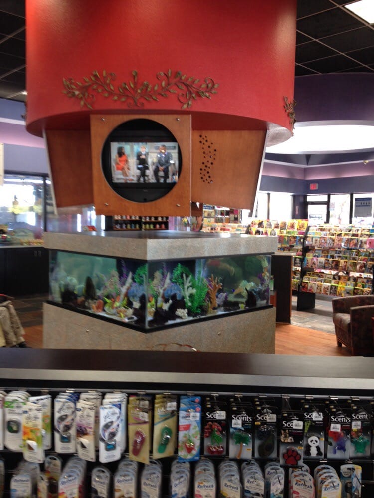 A fish tank in a store with a tv above it