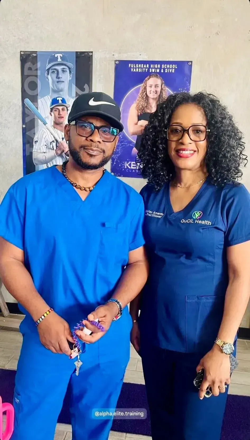 A man and a woman in blue scrubs are posing for a picture.