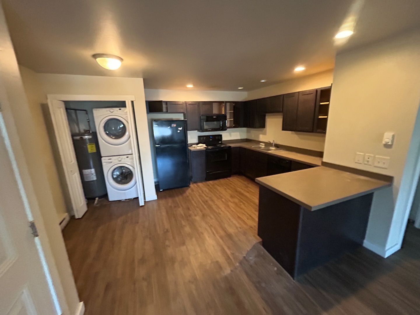 A kitchen with a washer and dryer stacked on top of each other.