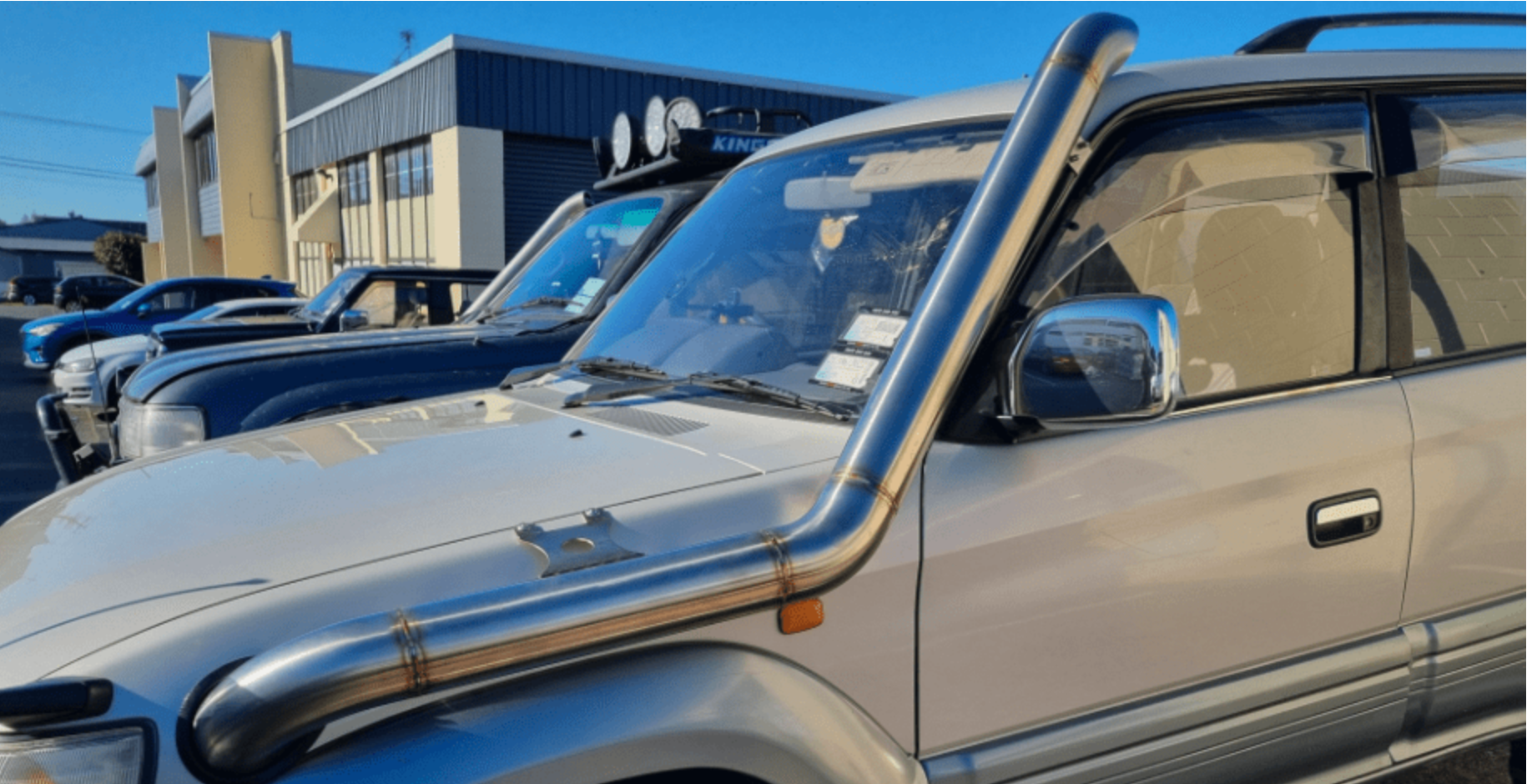 A row of toyota land cruisers parked in front of a building.