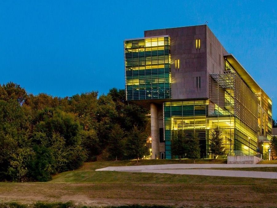 A large building with a lot of windows is lit up at night