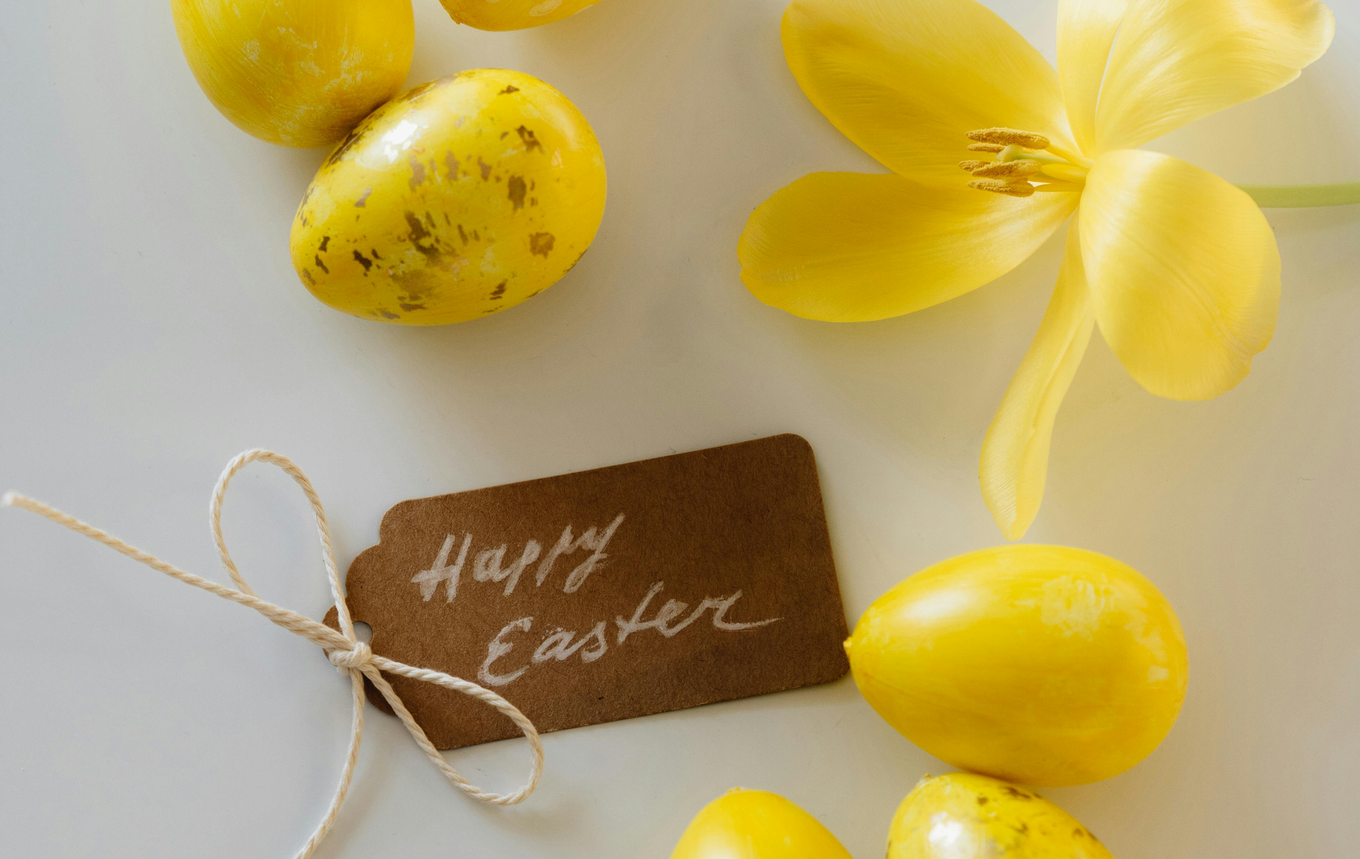 Happy Easter tag next to a yellow lily and yellow eggs