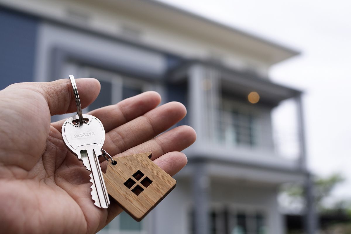 Hand holding keys to house