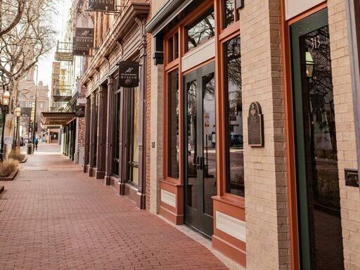A row of stores are lined up on a brick sidewalk in downtown fort worth.