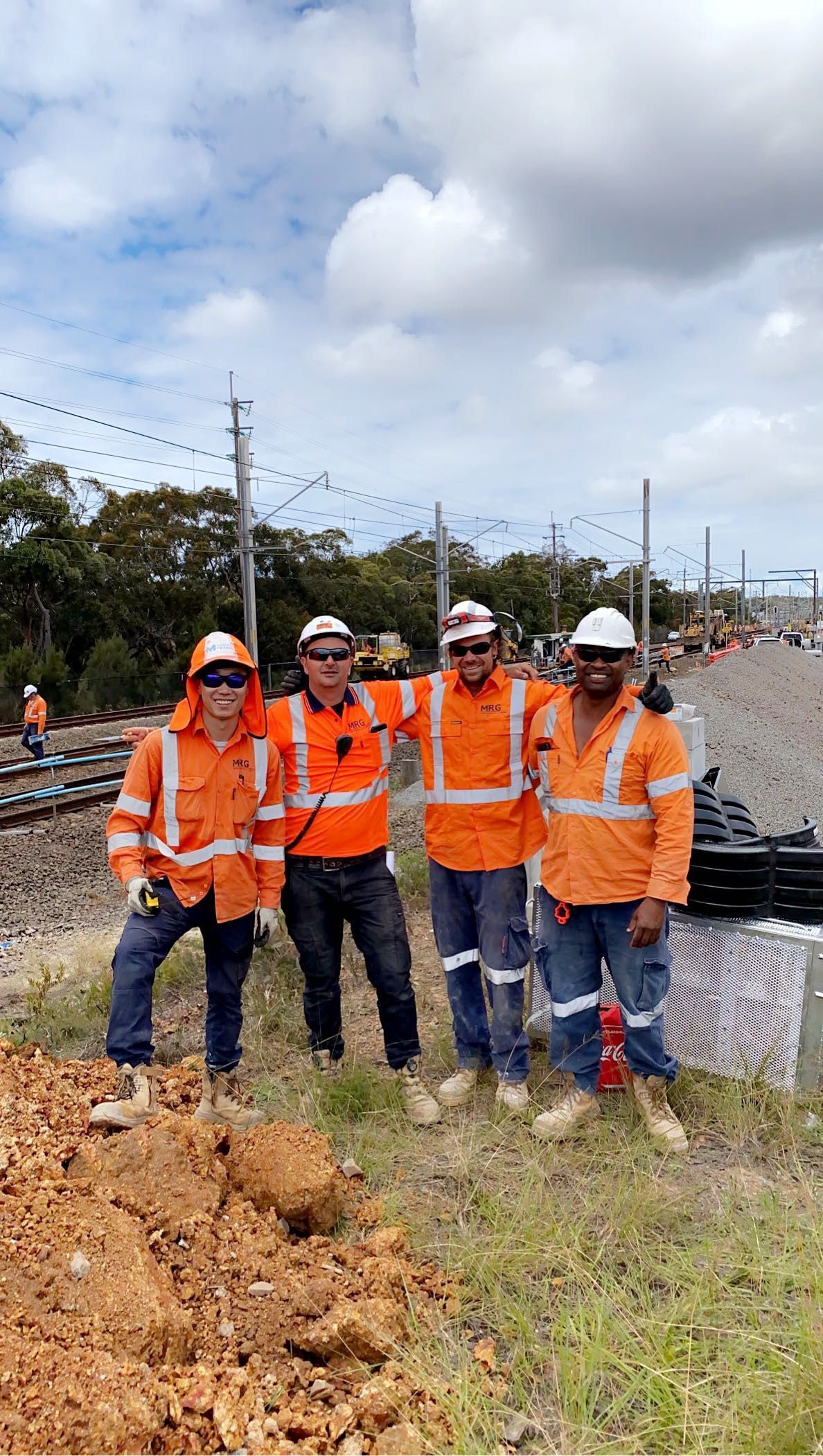 A group of construction workers are posing for a picture in a field.