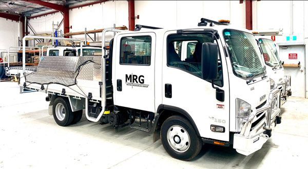 A white truck is parked in a warehouse.