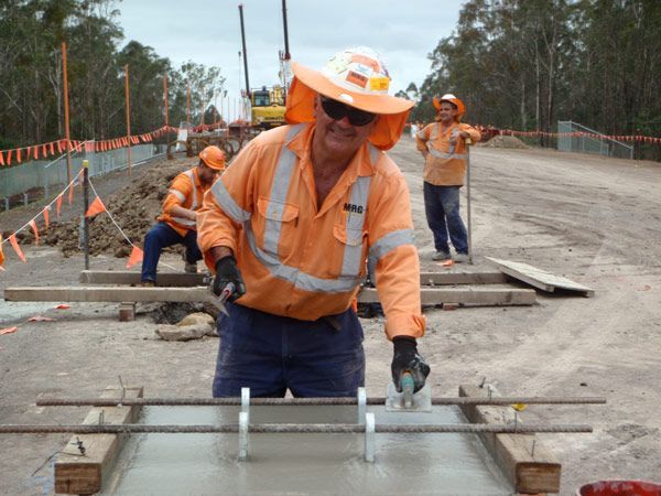 A man wearing a hard hat is working on a construction site