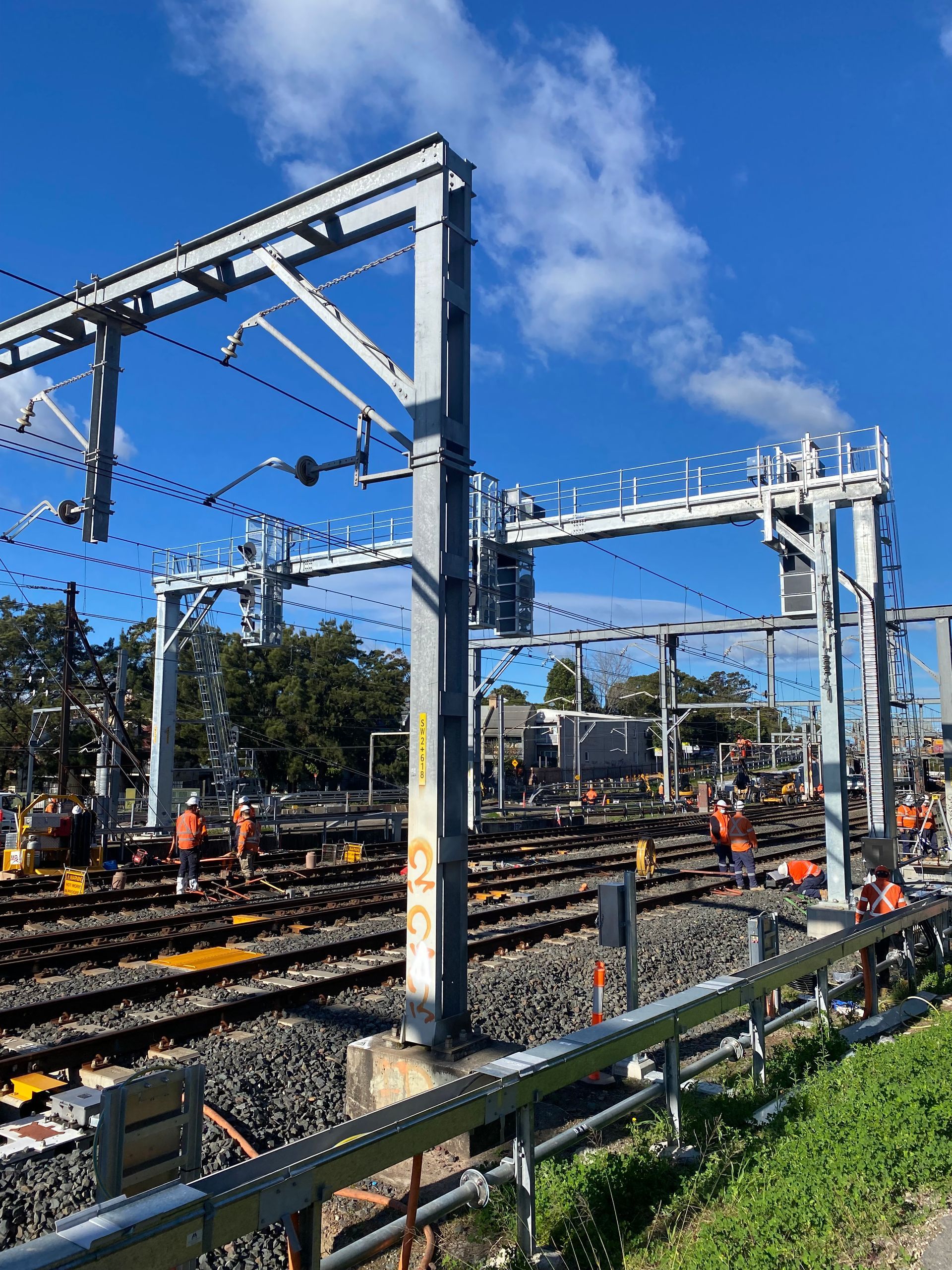 A train yard with a lot of tracks and a blue sky in the background.