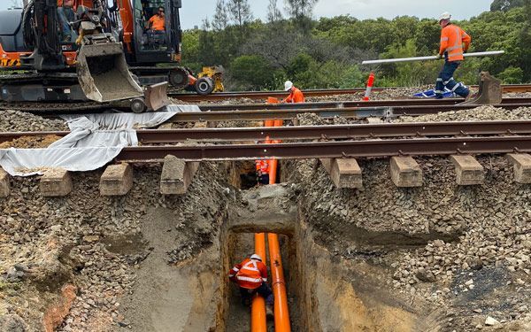A group of construction workers are working on a train track.