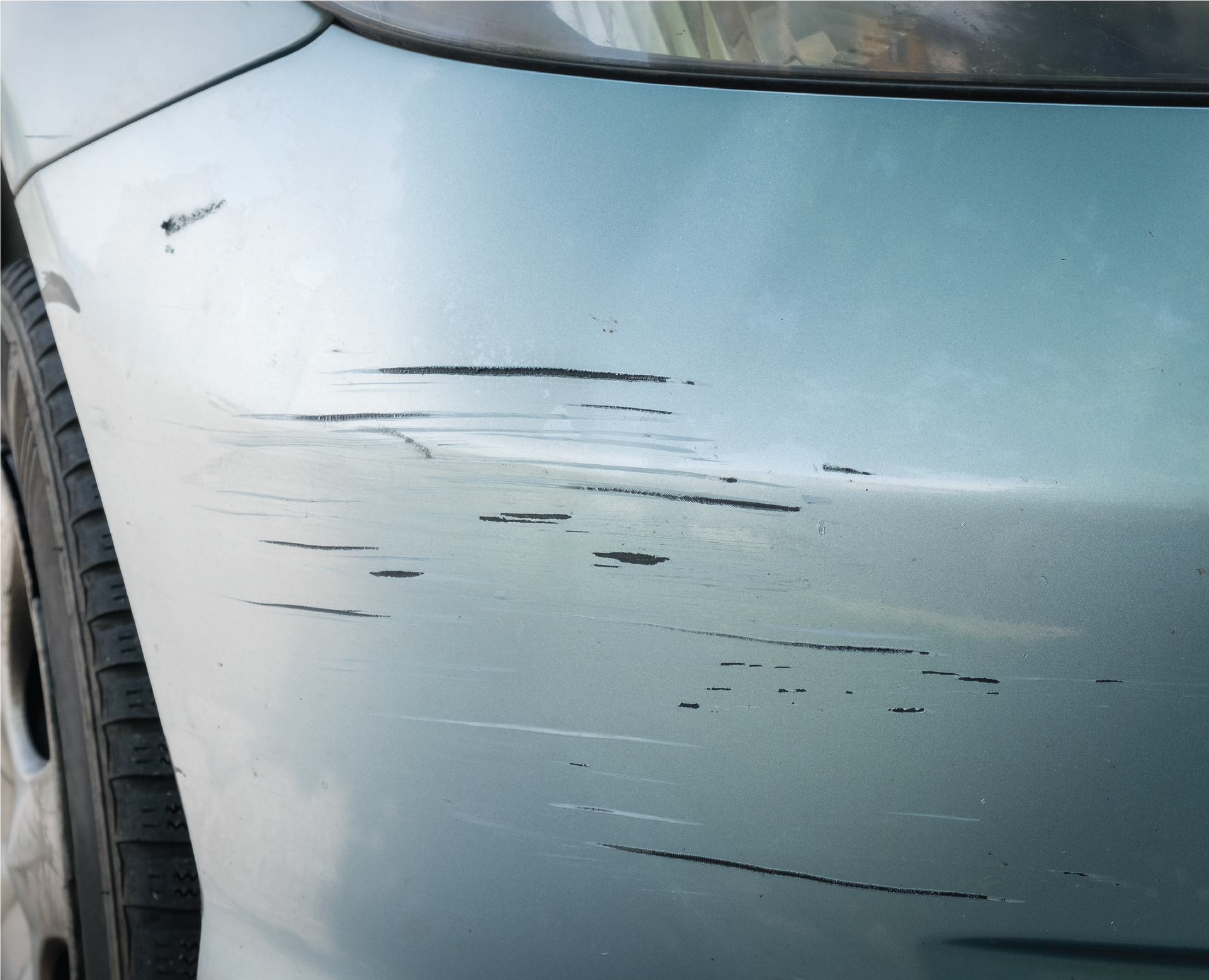 A close up of a car with a scratch on the front bumper