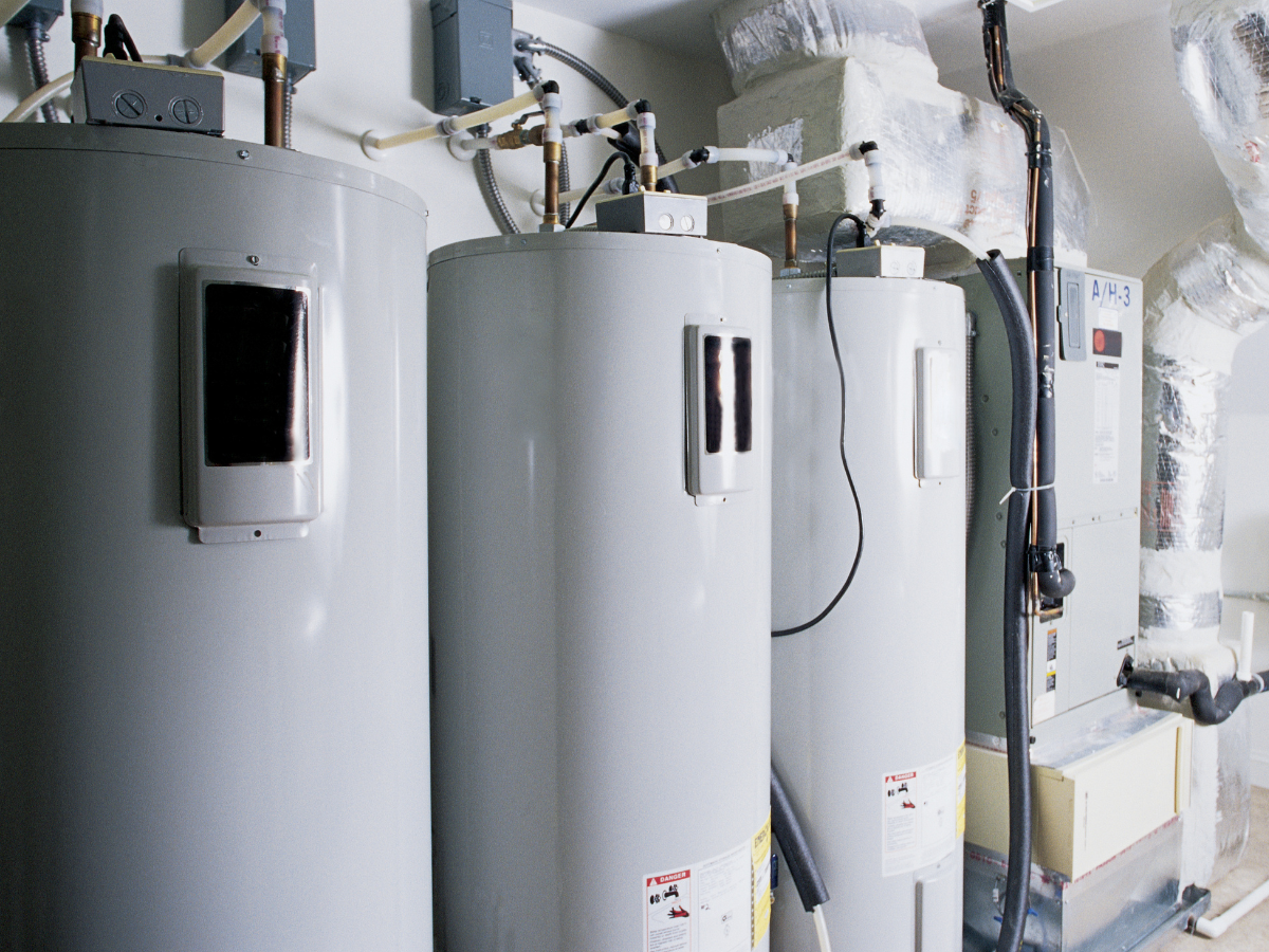 Two water heaters are sitting next to each other in a room.