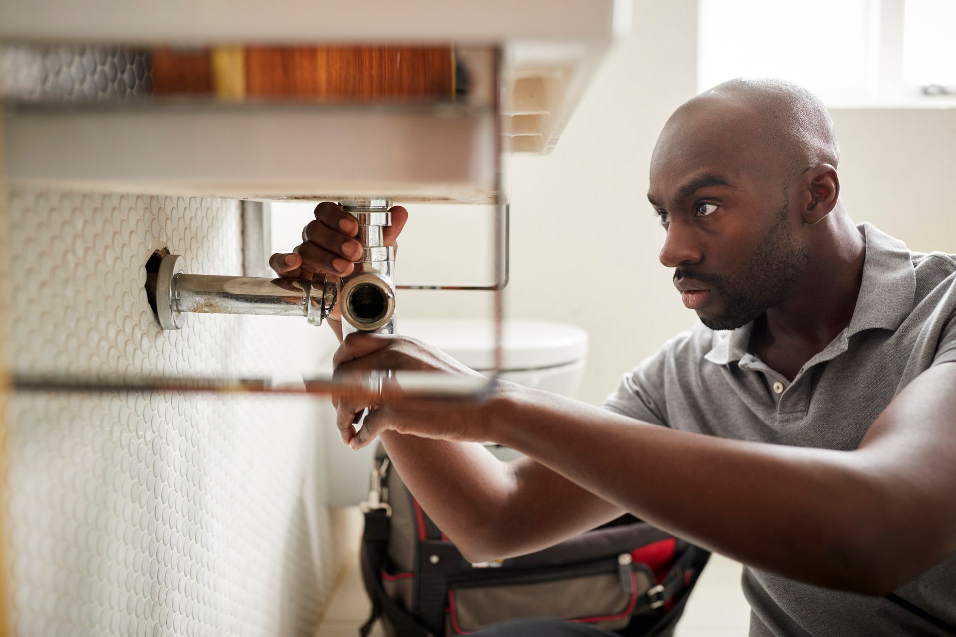 Plumber fixing a bathroom sink, providing expert plumbing services from a trusted plumbing company.