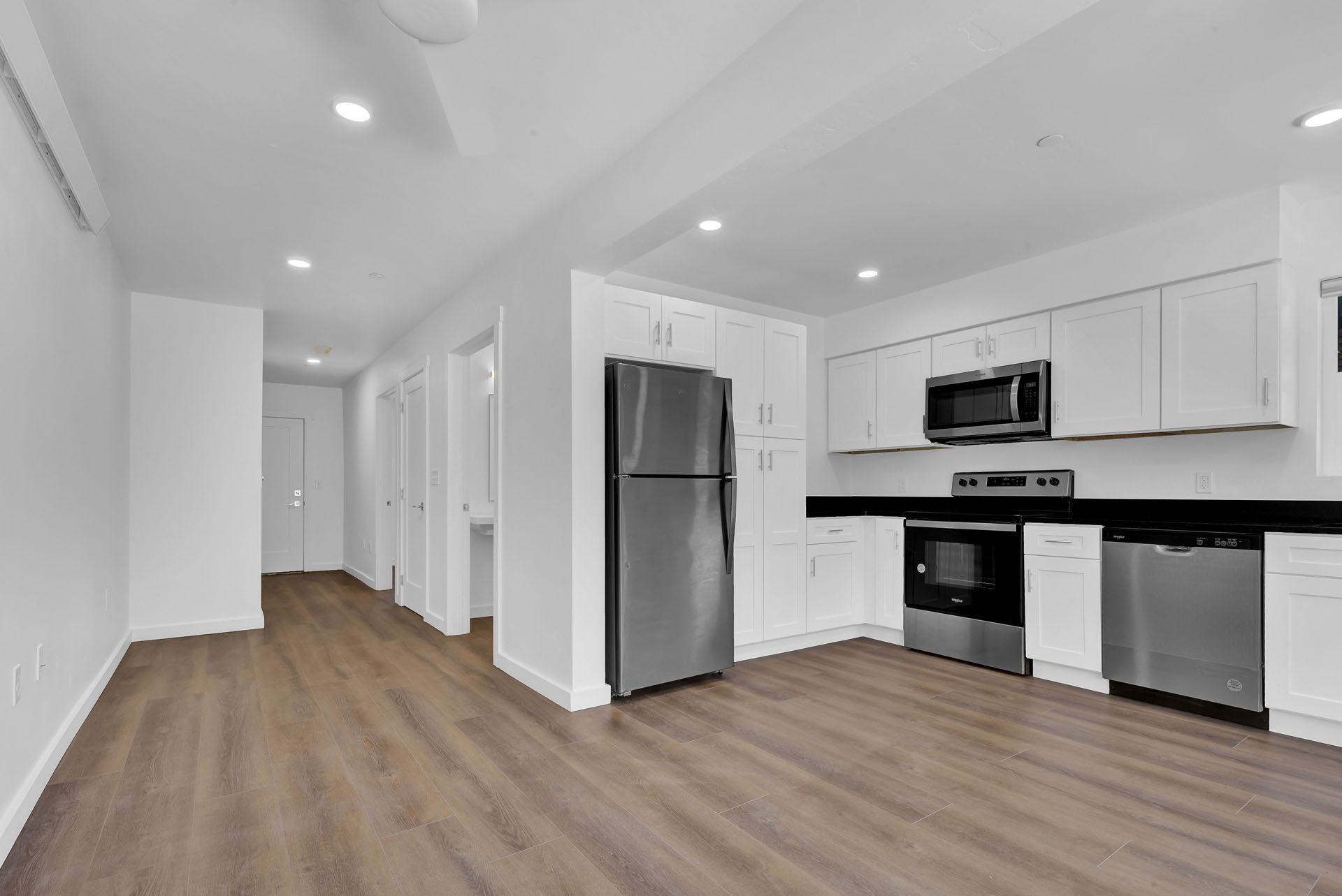 A kitchen with stainless steel appliances and white cabinets.