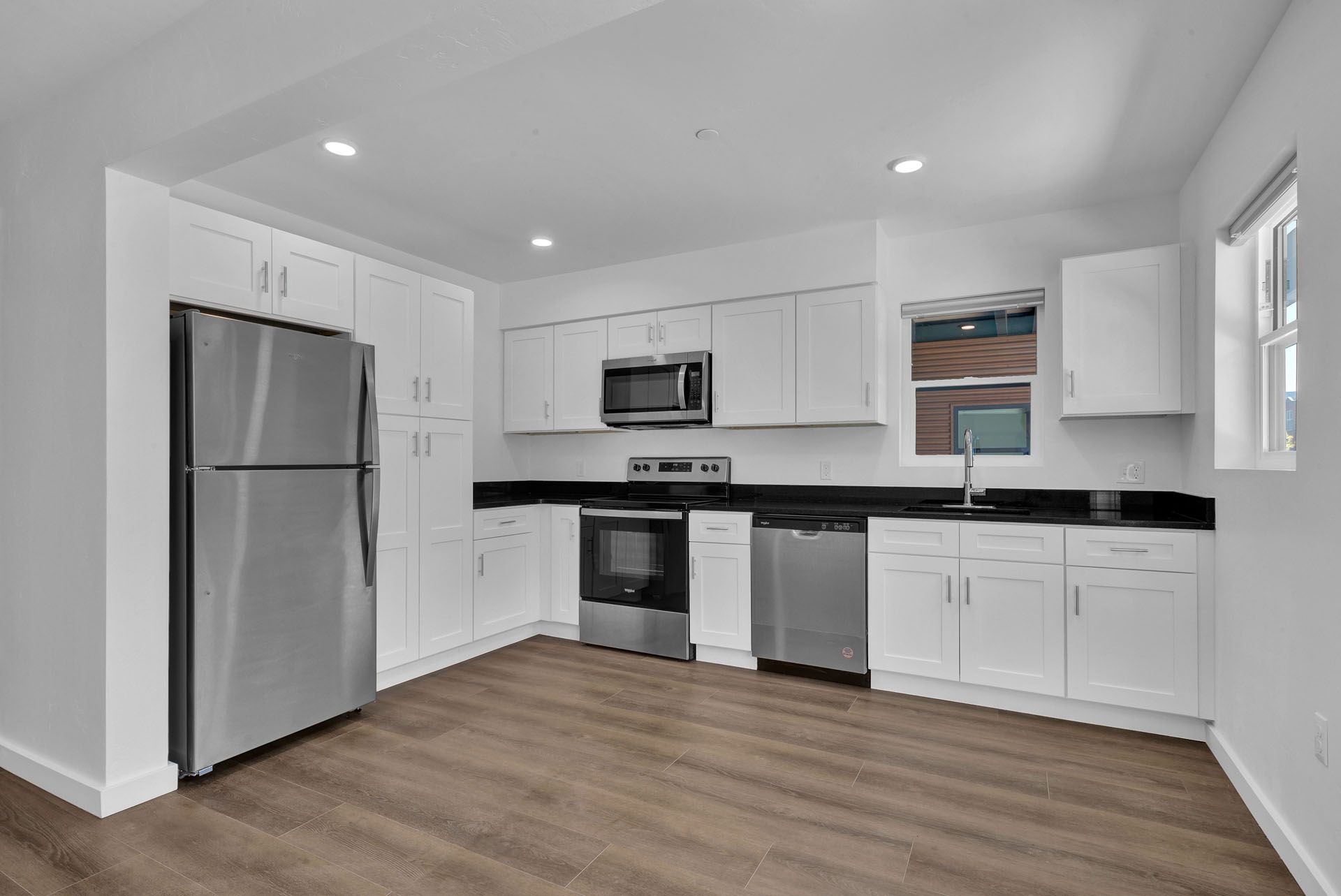 A kitchen with stainless steel appliances and white cabinets.