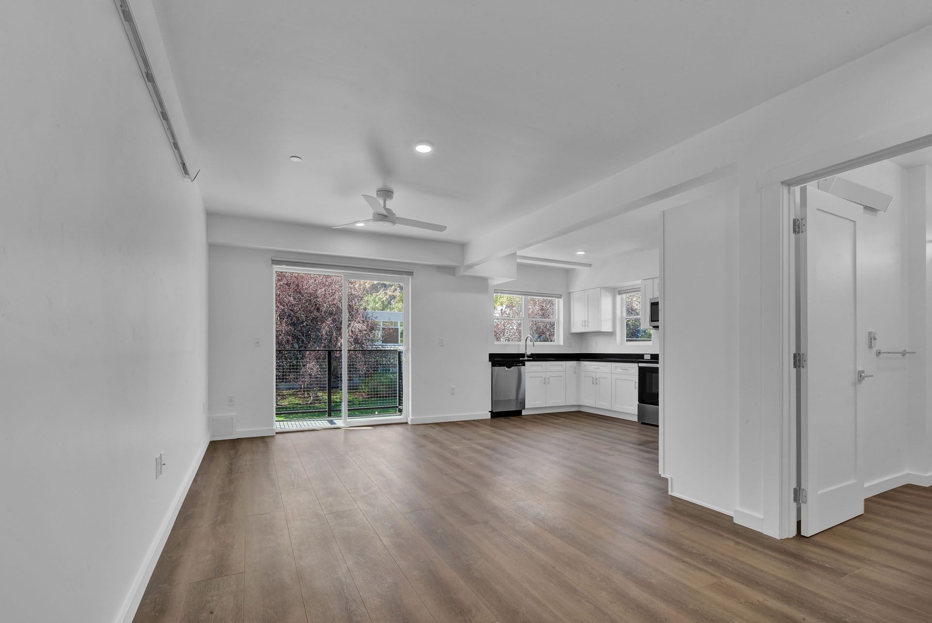 An  living room with hardwood floors and a ceiling fan.