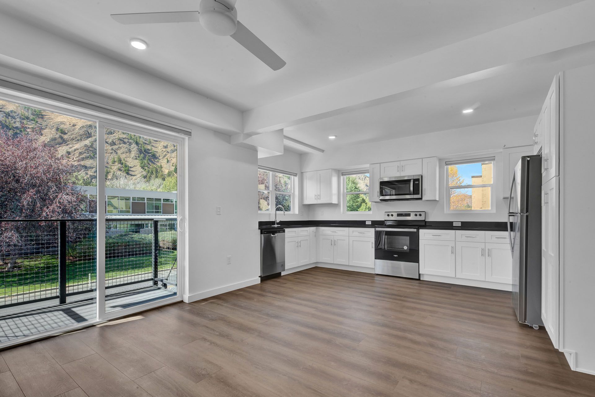A kitchen with a ceiling fan and sliding glass doors.