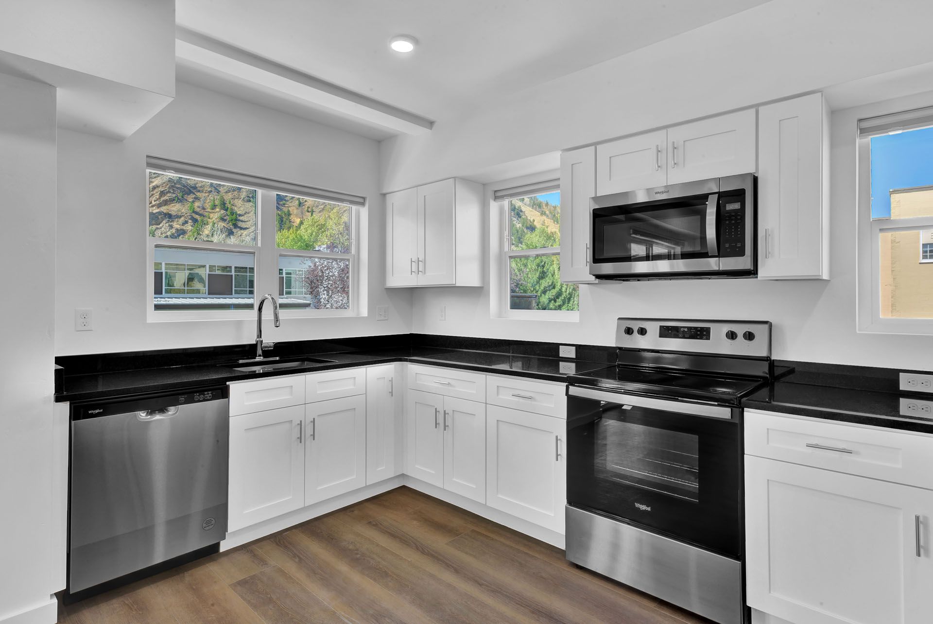 A kitchen with stainless steel appliances and white cabinets.