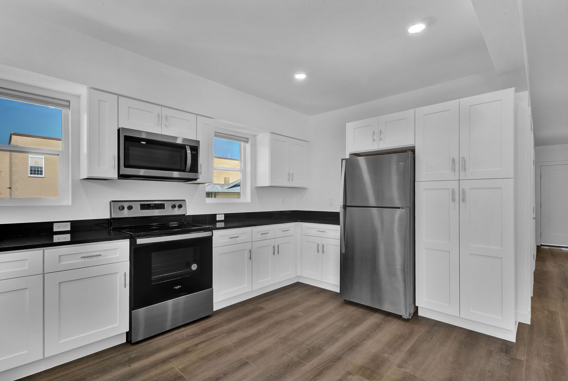 A kitchen with stainless steel appliances and white cabinets.