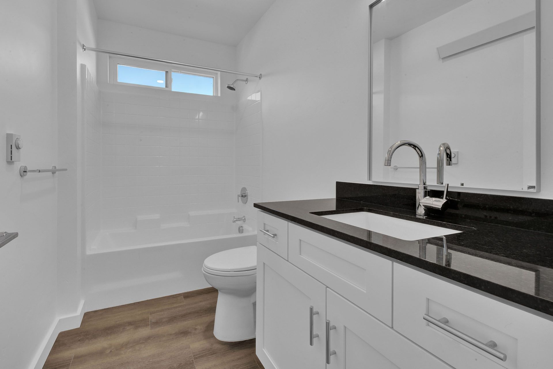 A bathroom with a toilet , sink , and bathtub.