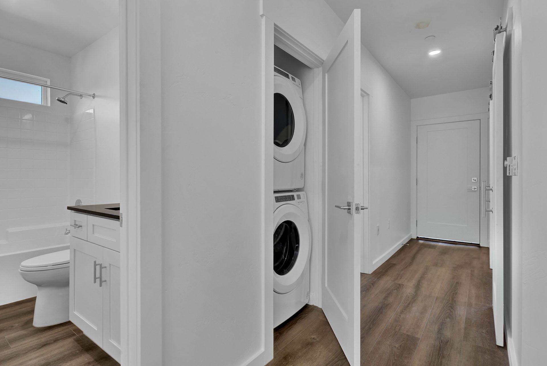 A bathroom with a washer and dryer stacked on top of each other.