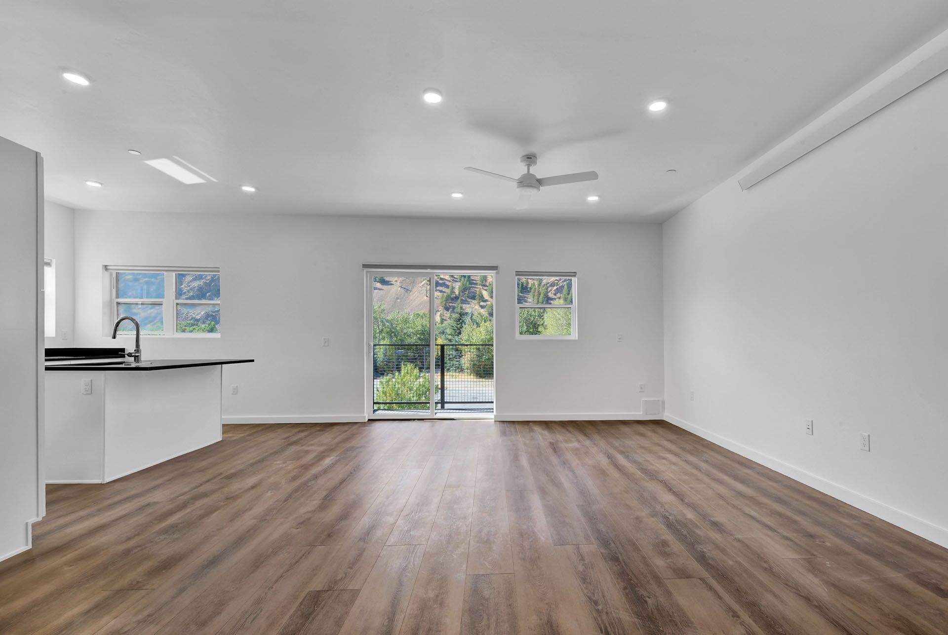 A living room with hardwood floors and a ceiling fan.