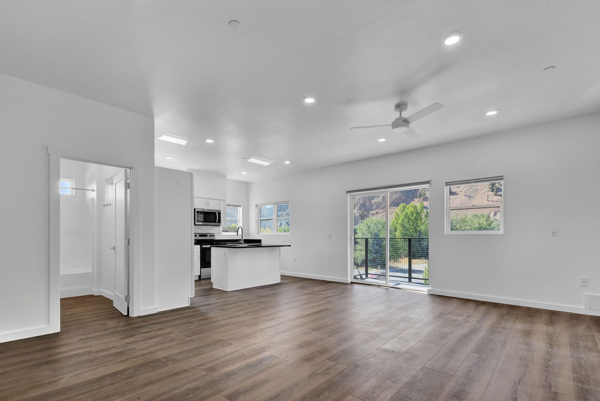 An  living room with hardwood floors and a ceiling fan.
