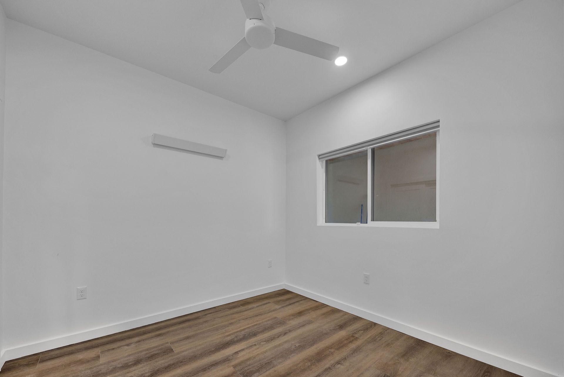 A room with a ceiling fan and a window.