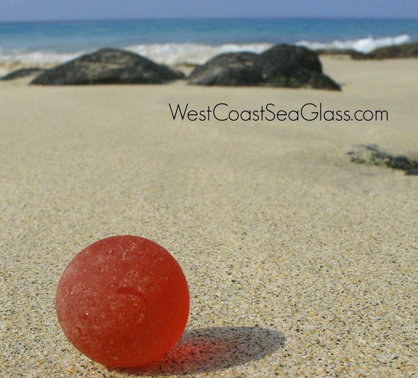 Perfectly round, natural sea glass marble on the beach