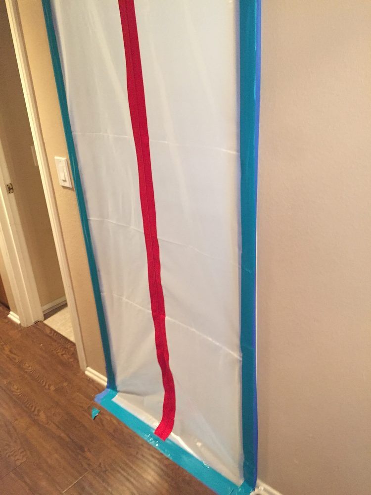 White screen with blue and red taped borders, set near a wall, indoor.