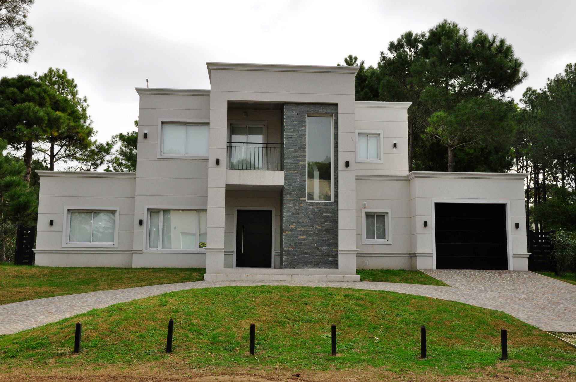 Casa moderna de dos plantas con exterior de estuco gris claro