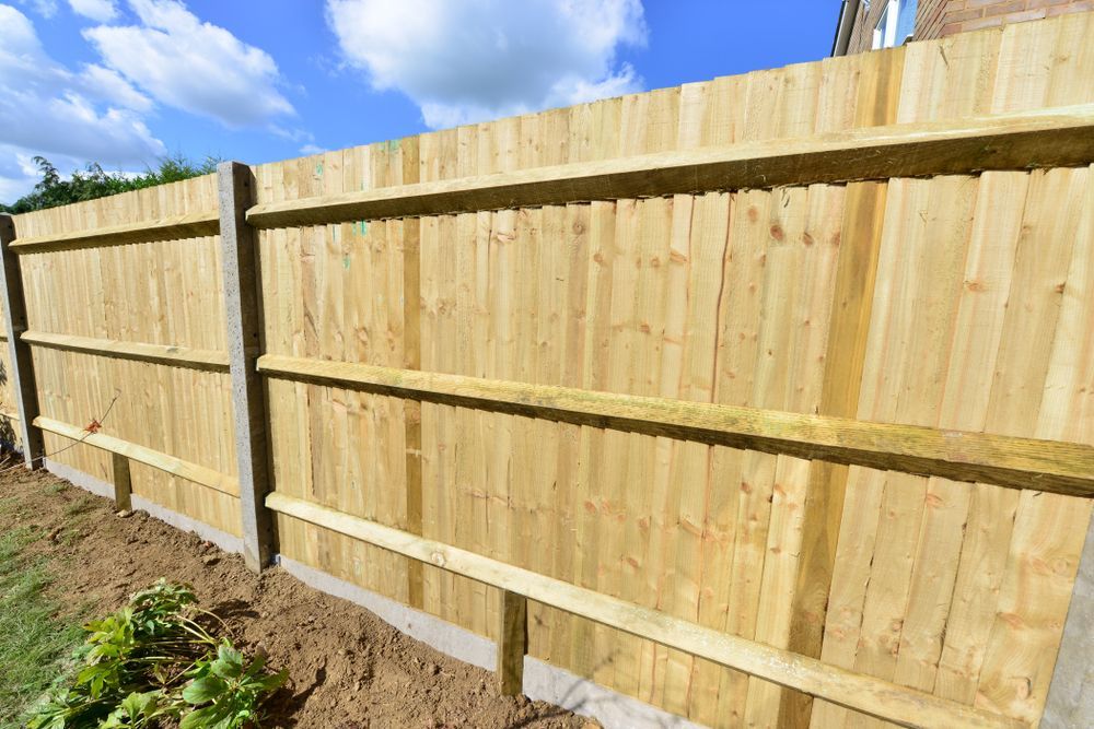 Wooden Privacy Fence Panels Along a Yard Under a Blue Sky — Everyday Maintenance Pty Ltd In Beaconsfield, QLD