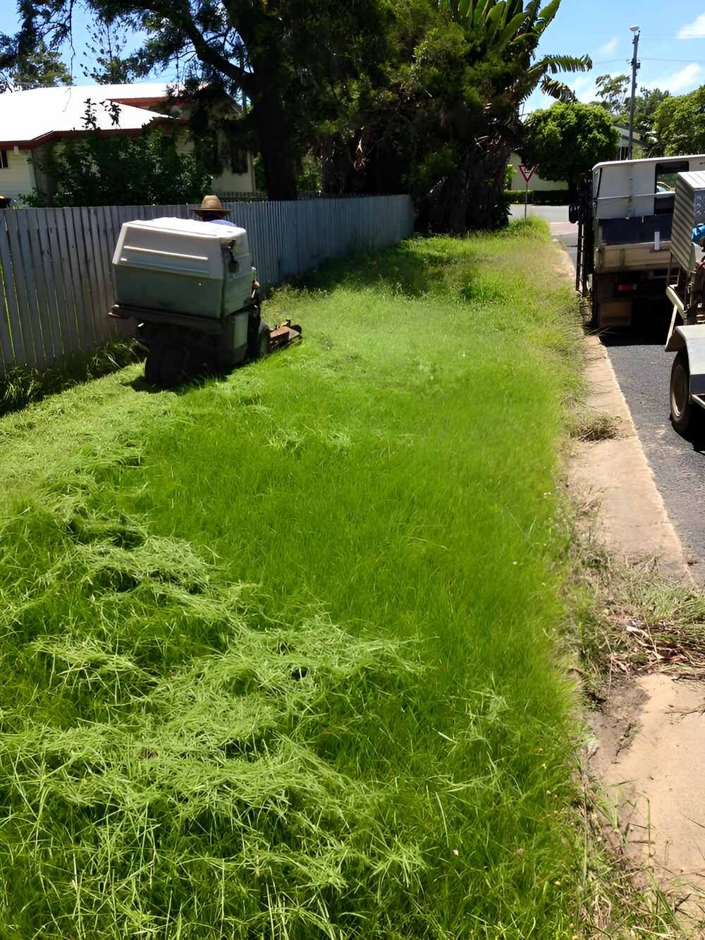 A Truck Is Parked On The Side Of The Road Next To A Lush Green Field — Everyday Maintenance Pty Ltd In Beaconsfield, QLD