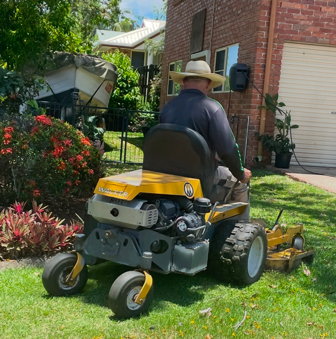 A Lawn Mower Is Cutting A Lush Green Lawn — Everyday Maintenance Pty Ltd In Beaconsfield, QLD