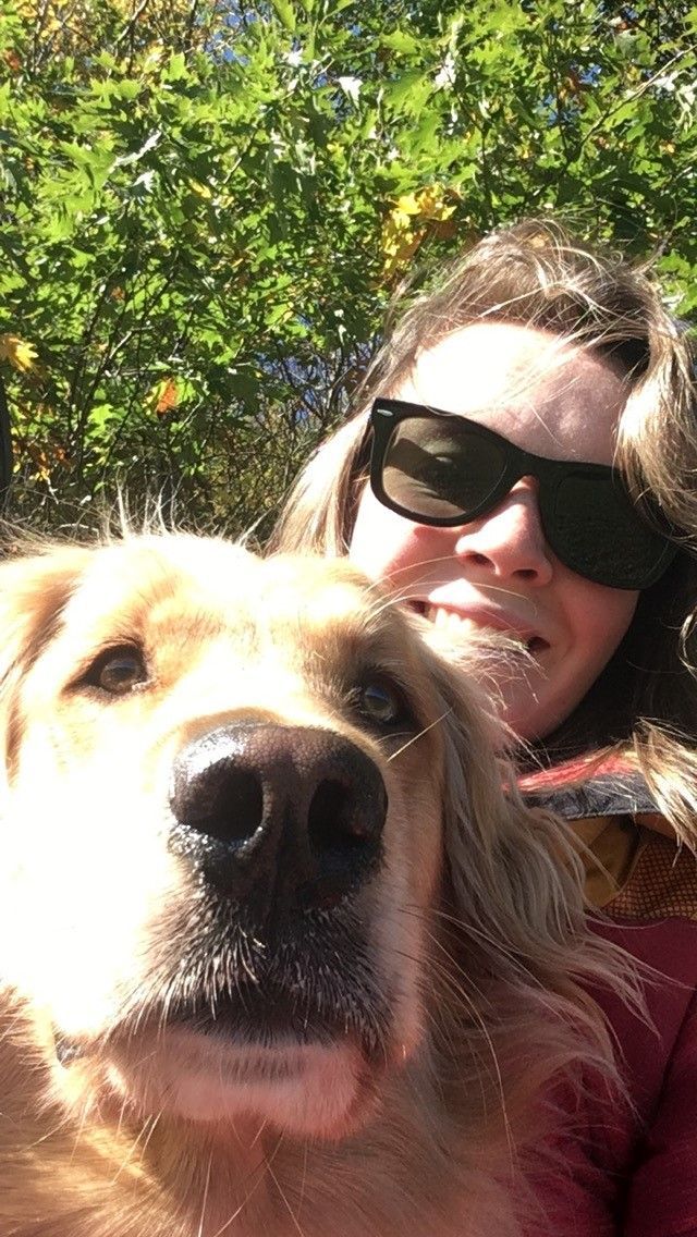 Adrienne Phelps, wearing sunglasses, and her dog, smile at the camera