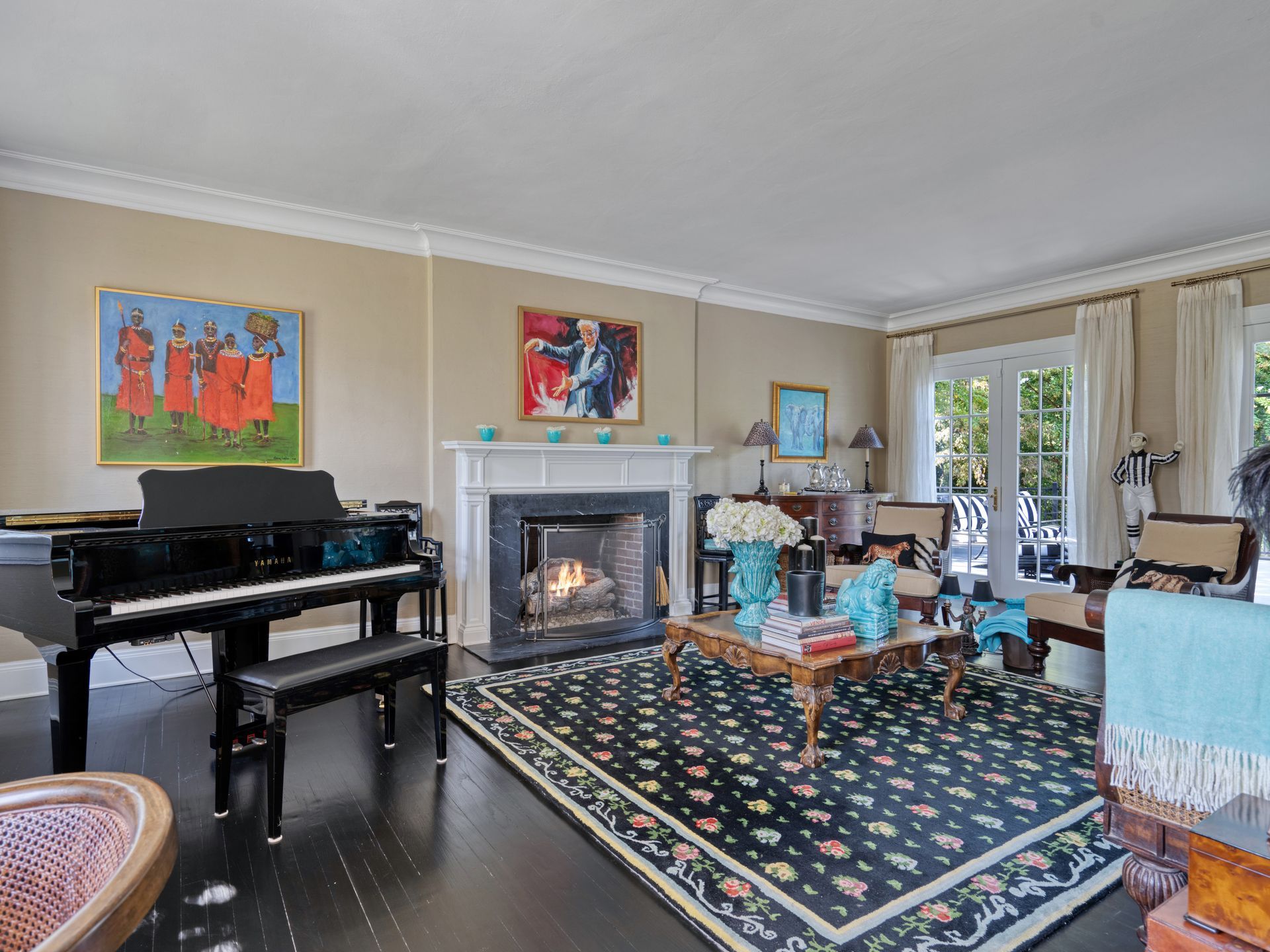 Living room with piano, fireplace, and ornate rug. Beige walls, black floor, and two doorways.