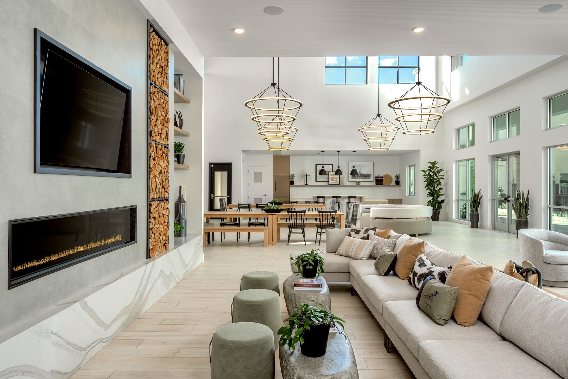 Spacious modern lounge with fireplace, large sofa, pendant lights, and dining area.