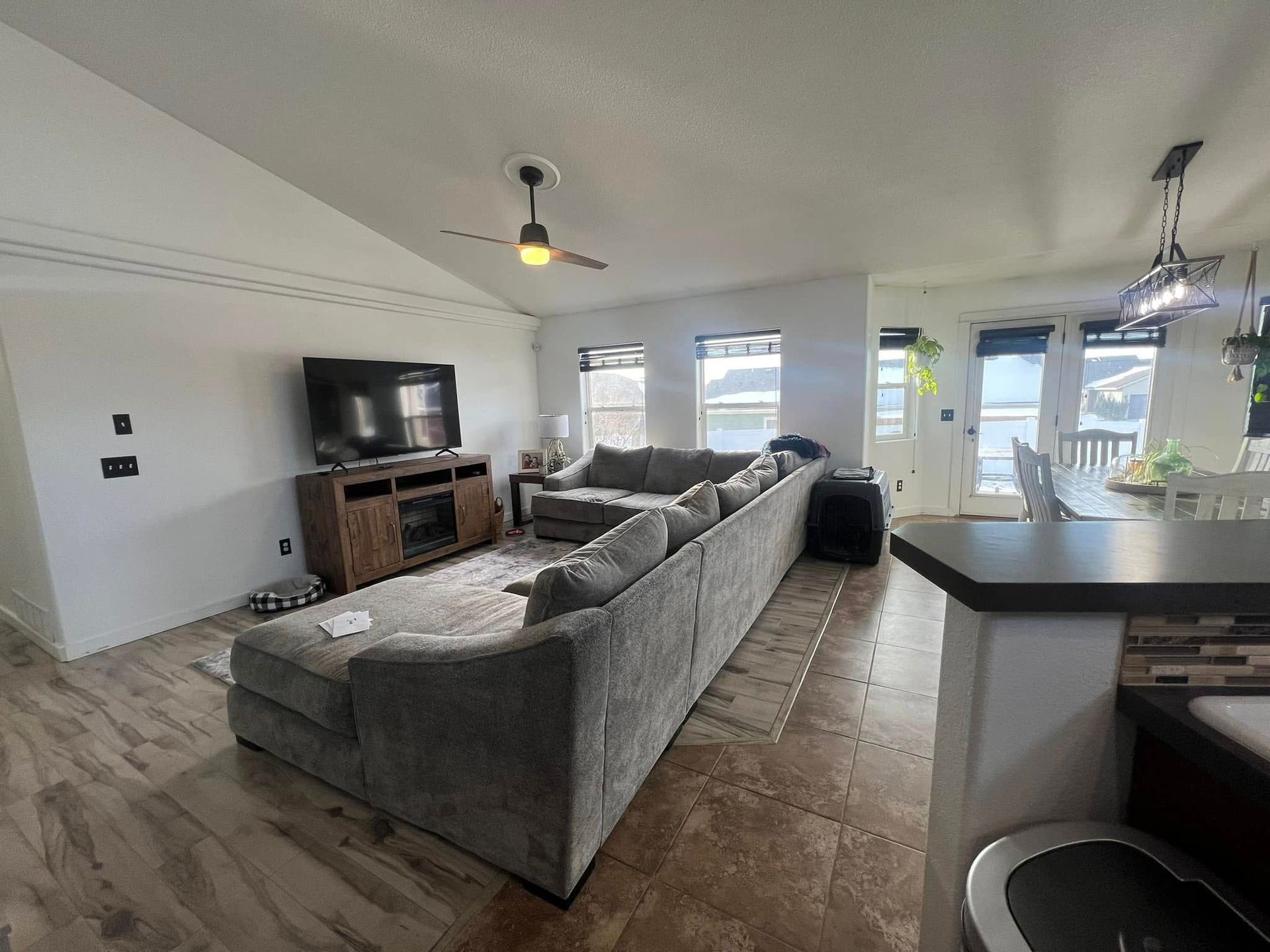 A living room with a large sectional couch and a flat screen tv.