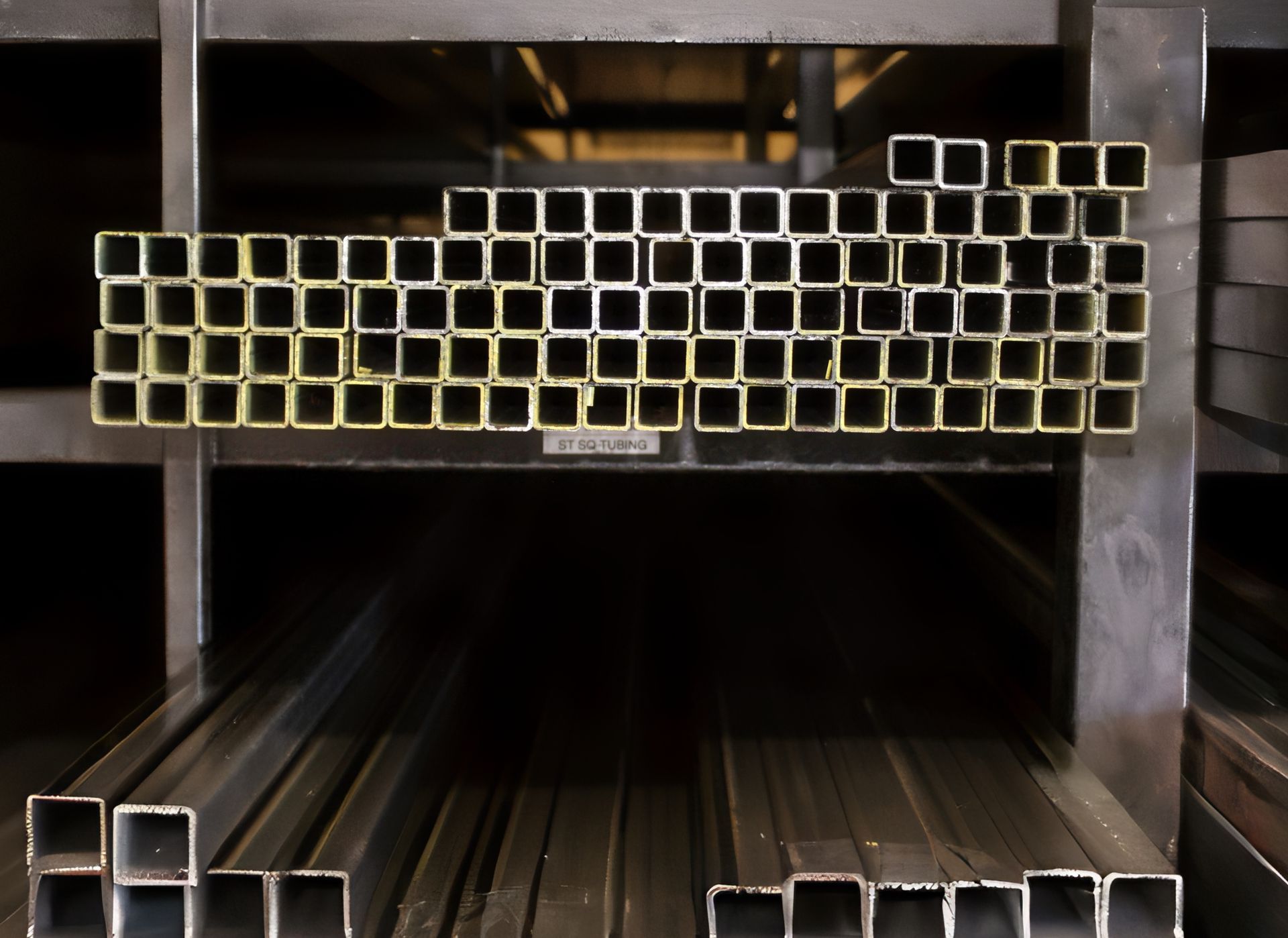 Metal square tubing stacked on shelves.
