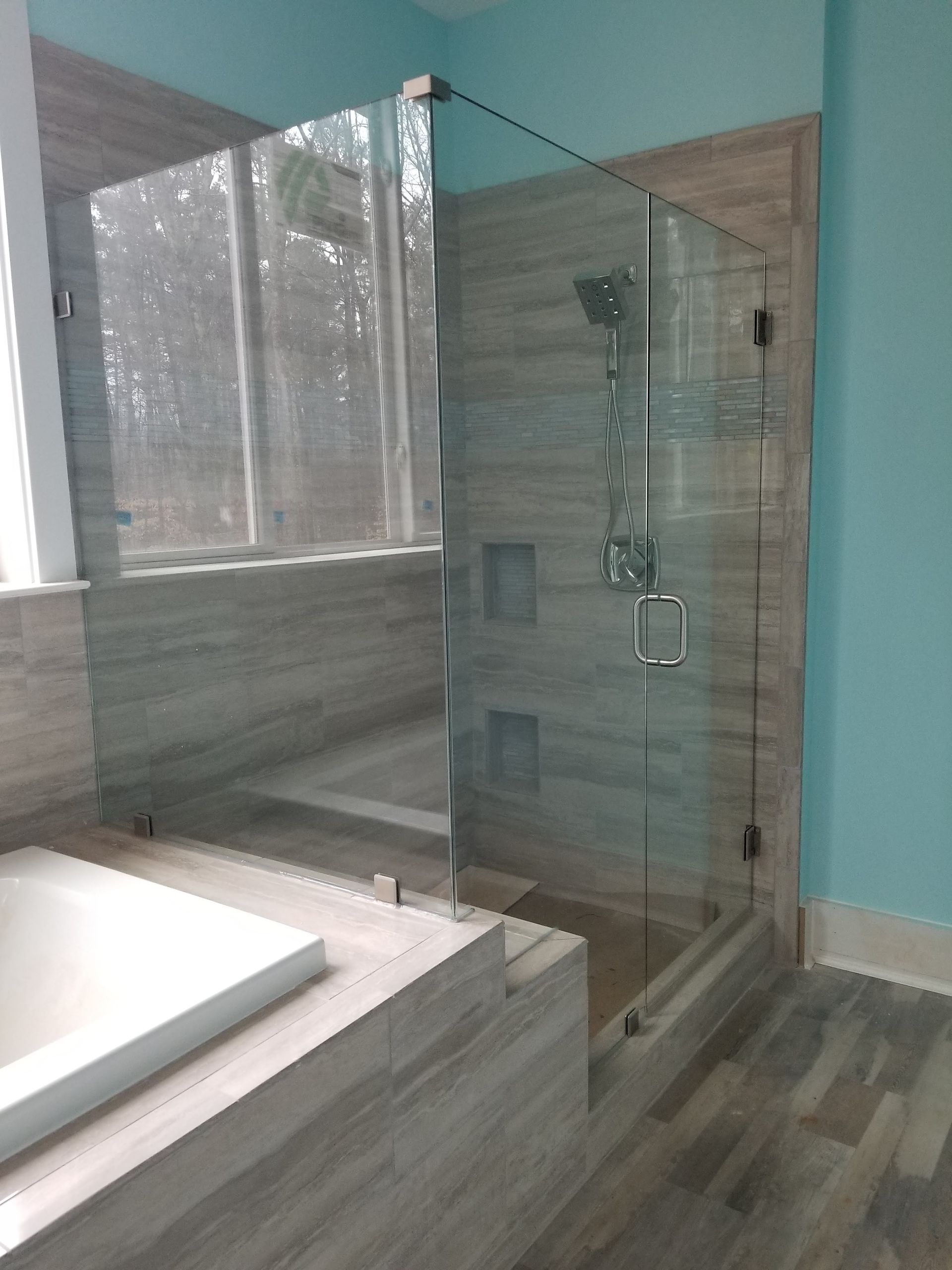 A bathroom with a walk in shower and a bathtub.