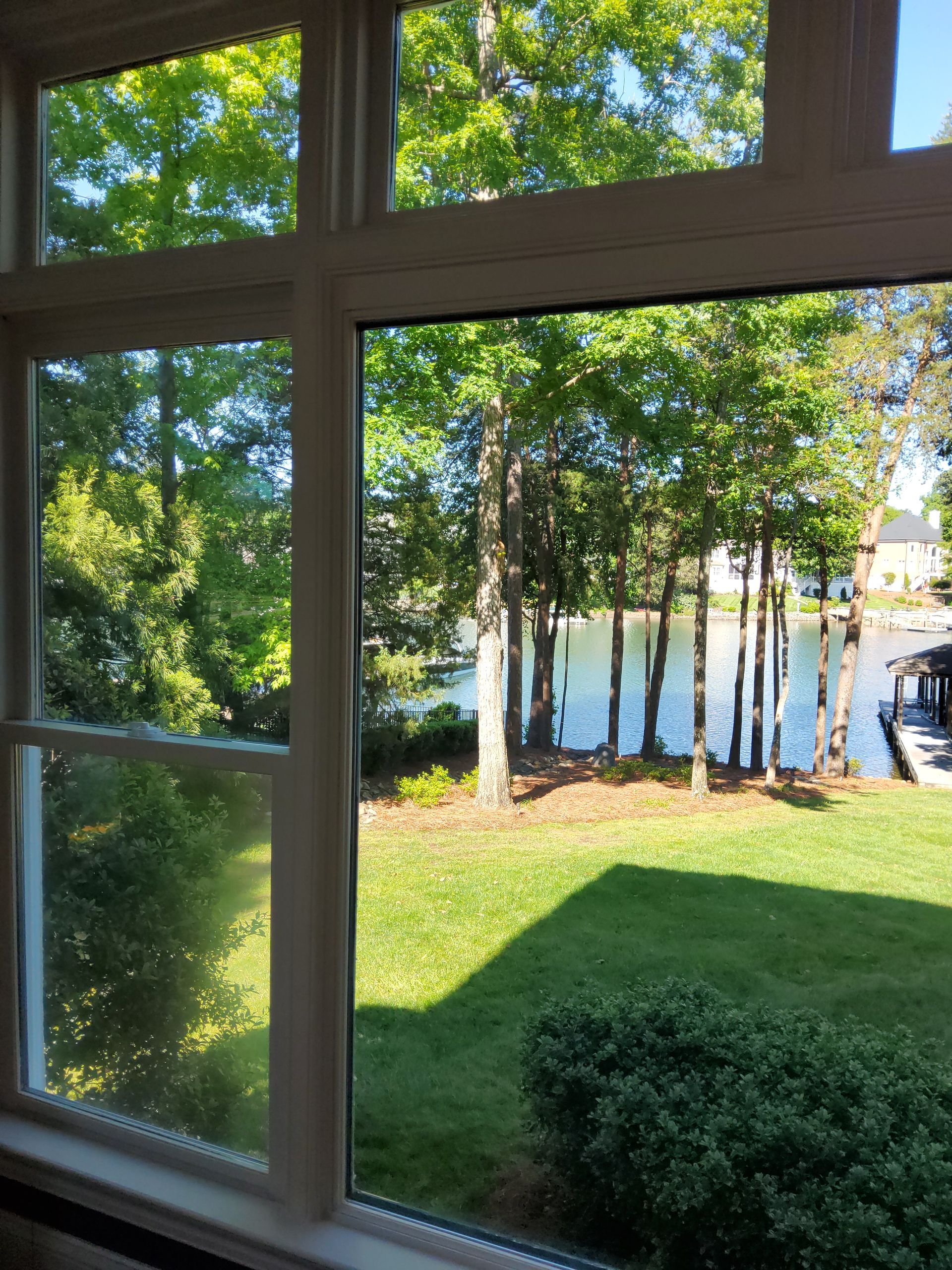 A view of a lake through a window with trees in the background