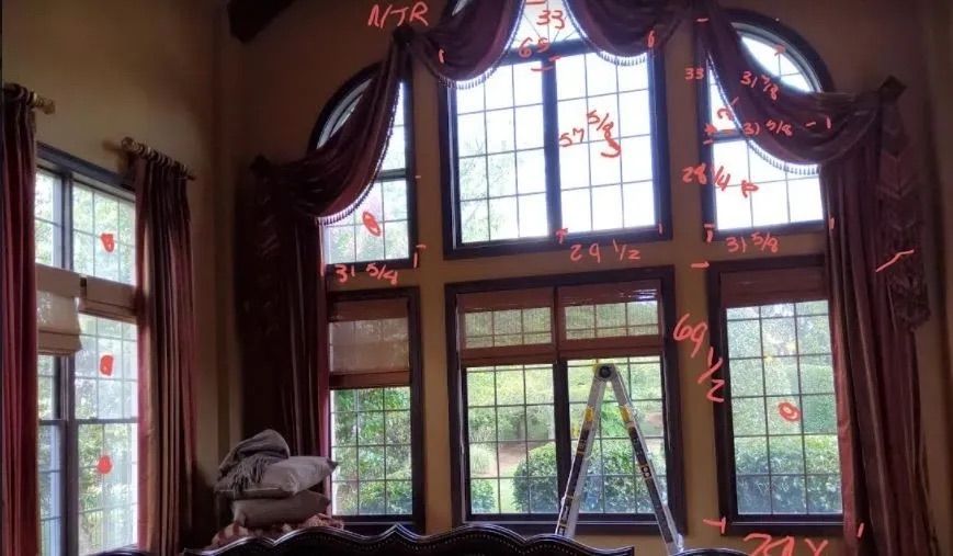 A living room with a lot of windows and curtains