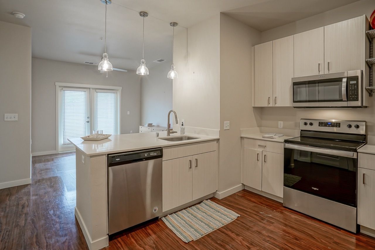 Modern kitchen with an island, stainless steel appliances, and white cabinets.