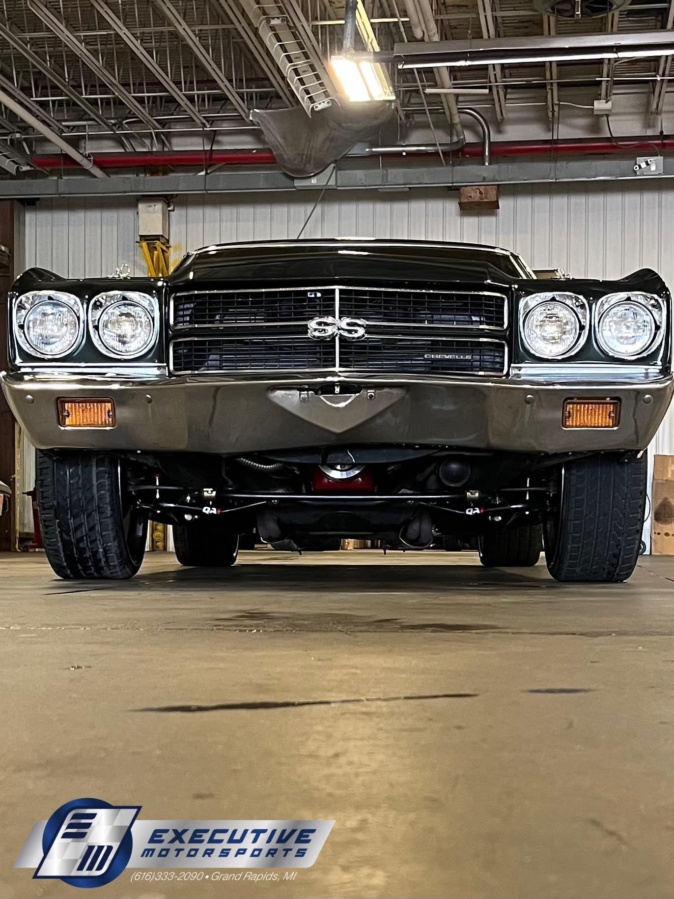 Black classic car front view, silver bumper, orange side markers, 