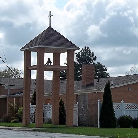 A bell tower with a cross on top of it