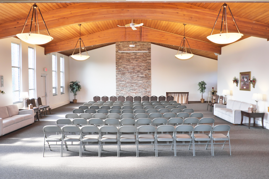 A large room with rows of chairs and a fireplace