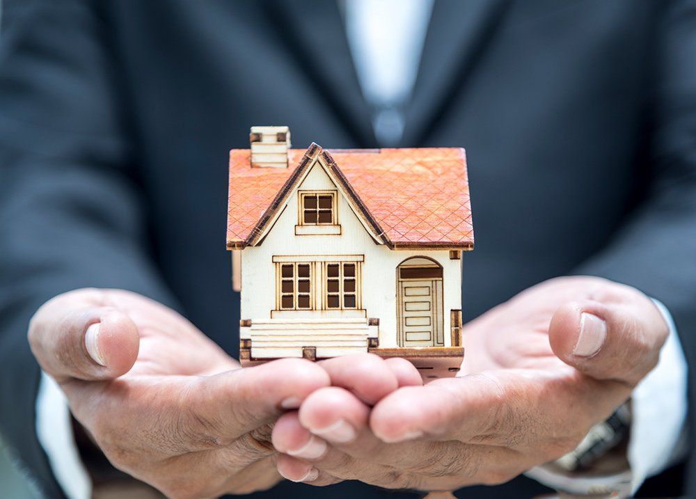 Person Holding A Home Model — Chicago, IL — Metropolitan Insurance Service Consultants, Inc